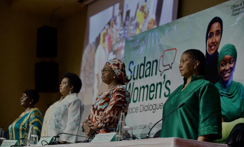 Women standing in front of screen and banner